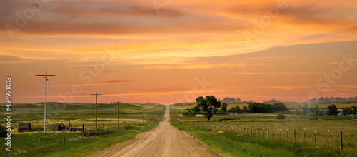 a county gravel road runs through farm land in north eastern Colorado east of Sterling