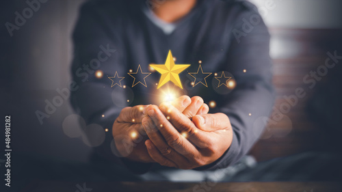 Businessman using hands to show the five-star symbol for highest satisfaction, 5-star feedback, reputation and quality, Concept of standardization and quality in products and services. photo