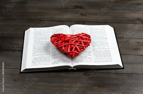 Open book, Bible. On the table. Red heart. The concept of love for God and Scripture. photo