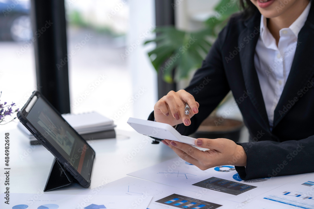 asian accountant woman working about financial with business report and calculator.financial or accounting concept. asian accountant woman working about financial with business report and calculator.financial or accounting concept.