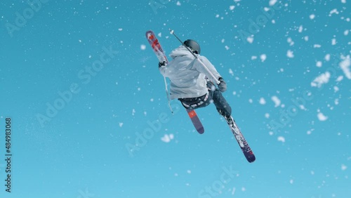 SLOW MOTION: Young male tourist on skiing trip rides around the fun park and does breathtaking tricks. Freestyle skier takes off the kicker and does a difficult 360 grab. Athletic traveler skiing.