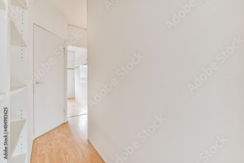 Interior of bright corridor with white walls and wooden shelfes photo