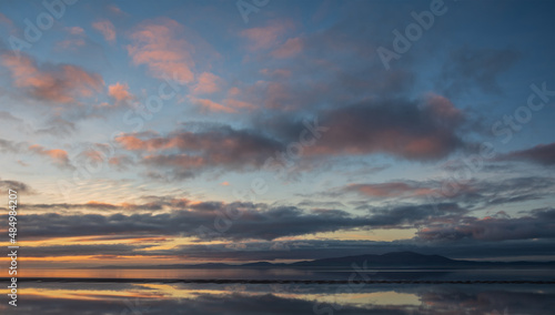 Beautiful sunset landscape image of Solway Firth viewed from Silloth during stunning Autumn sunset with dramatic sky and cloud formations