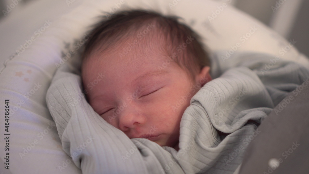 The child sleeps peacefully in a cocoon. Newborn baby sleeping face close-up. The child sleeps peacefully in a cocoon. Newborn baby sleeping face close-up.