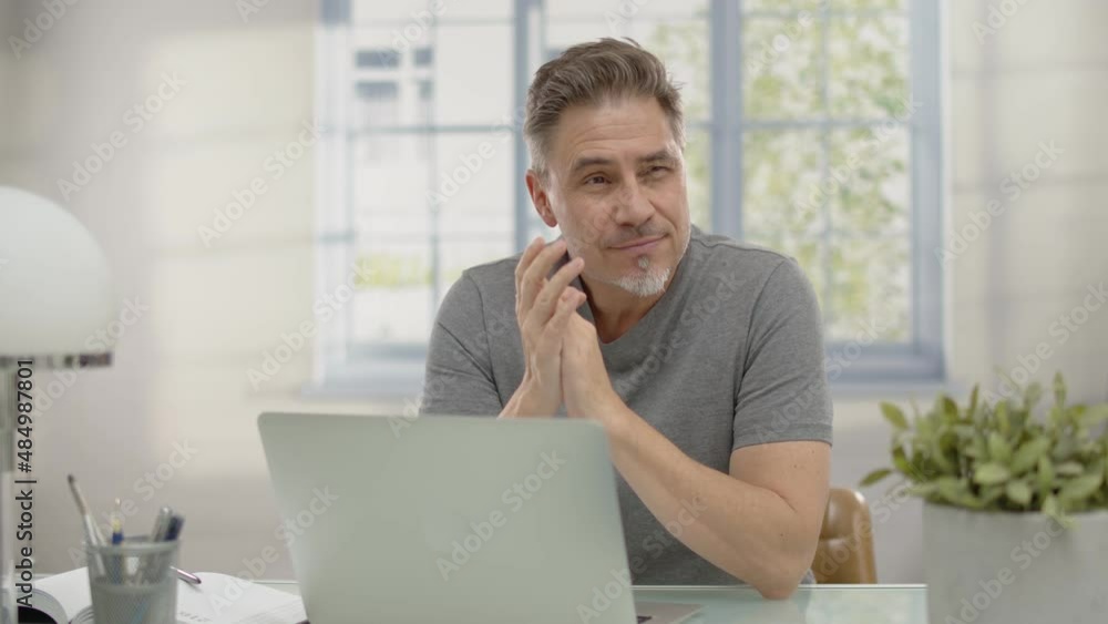 Happy older man with gray hair working at home in home office with laptop computer. Happy older man with gray hair working at home in home office with laptop computer.