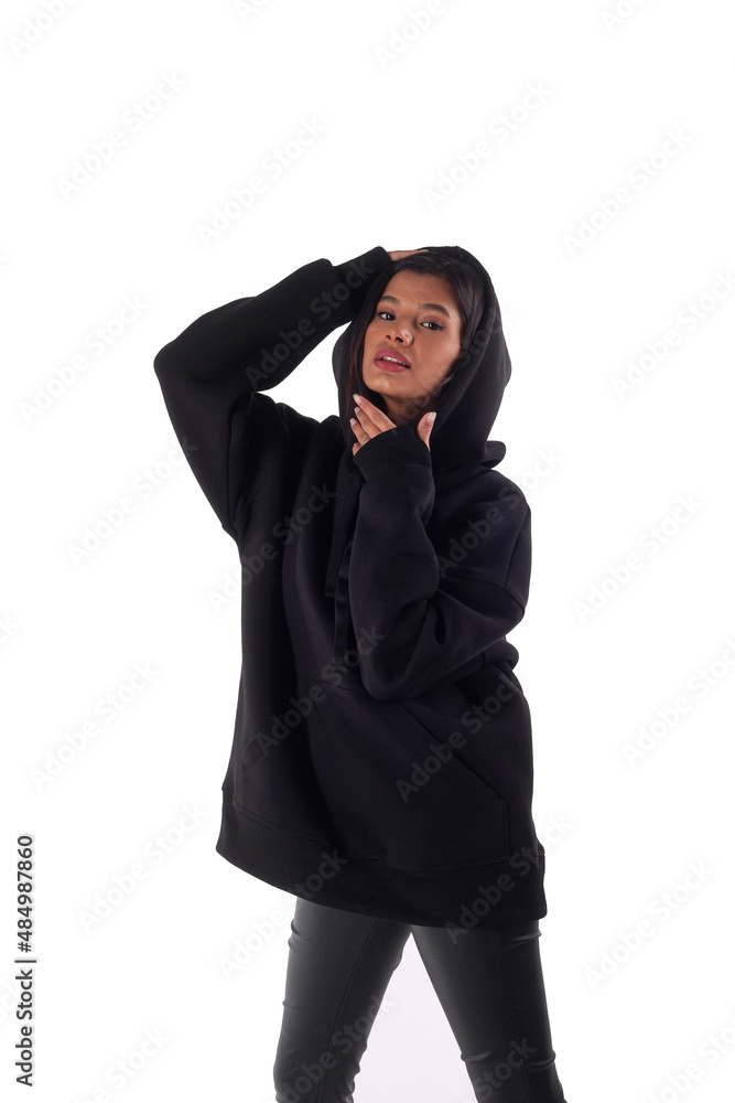 Attractive woman of Latin appearance wears a dark hoodie on a white isolated background. The girl looks sexy and happy. The elegant brunette is wearing a black sweatshirt. All-season clothing Attractive woman of Latin appearance wears a dark hoodie on a white isolated background. The girl looks sexy and happy. The elegant brunette is wearing a black sweatshirt. All-season clothing