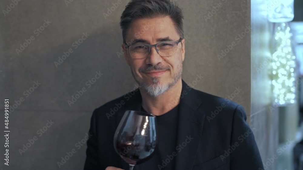 Portrait of man drinking red wine in restaurant. Professional wine expert, sommelier holding glass of wine, tasting, rating and reviewing. Portrait of man drinking red wine in restaurant. Professional wine expert, sommelier holding glass of wine, tasting, rating and reviewing.