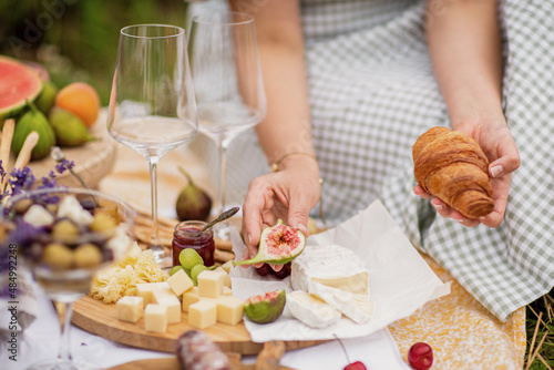 Close-up of food on the open diaphragm of food Summer season.Lavender fields. The girl 's hands holding a croissant .Picnic in the Countryside.
