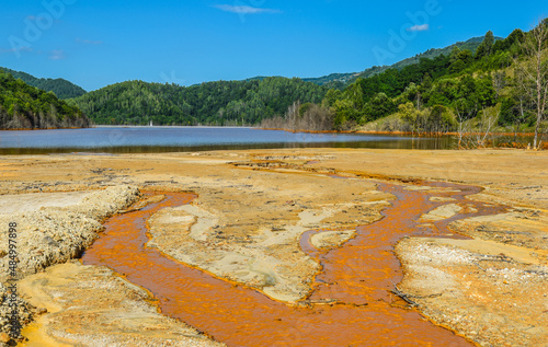Mountain lake landscape - liquid residues from a gold mine discharged into a lake, pollution