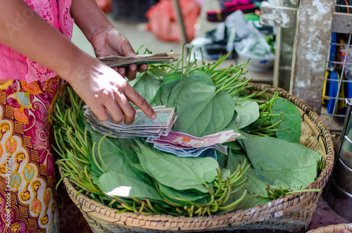 Woman pay for a basket of vegetables in Birma.