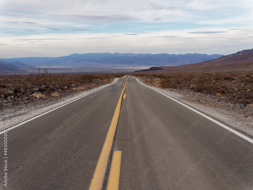 Straight road in the middle of a desert landscape Straight road in the middle of a desert landscape