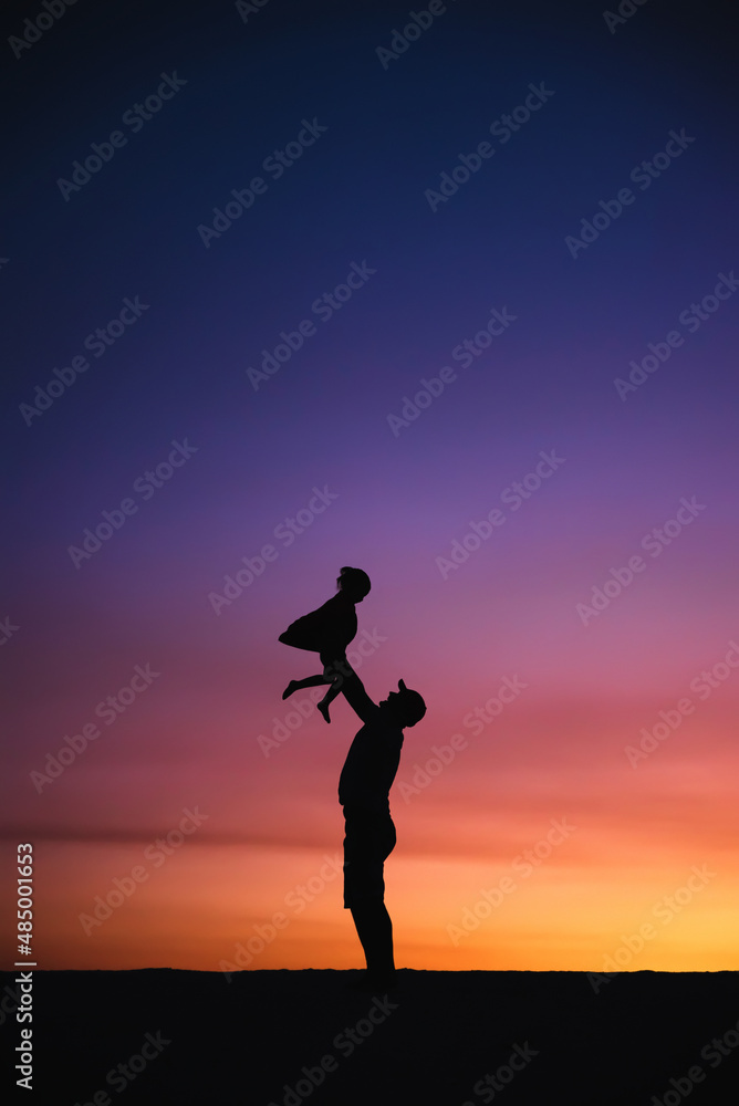 Father with baby during sunset.