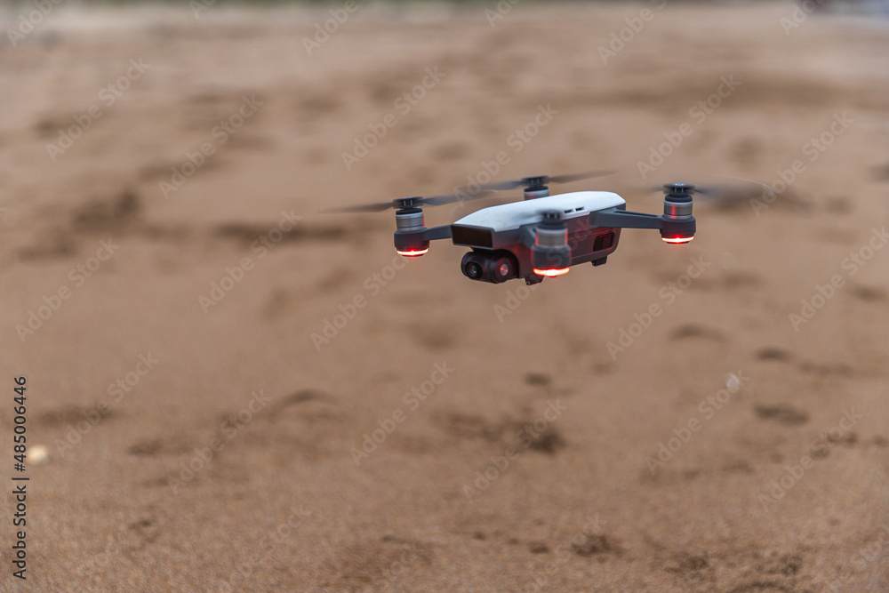 Drone qui vole au dessus de la plage. Drone télécommandé en l'air.  Plage en arrière plan.
