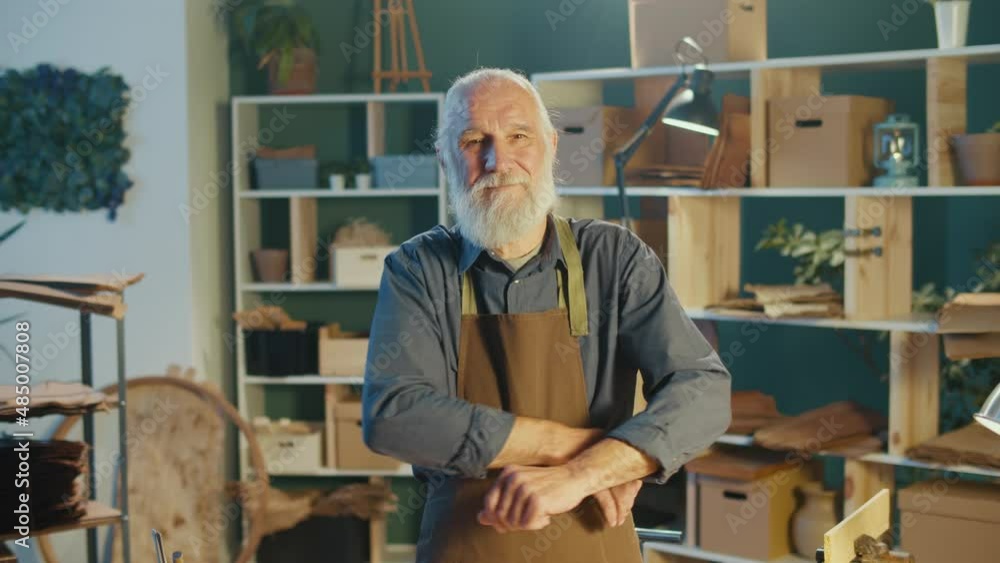 Portrait of a Senior, a Professional Carpenter in an Apron, Standing in an Authentic Carpentry Workshop with Warm Light. Hobby Garage, Carpentry, Crafts. Profession, Art and Hobby Concept. Portrait of a Senior, a Professional Carpenter in an Apron, Standing in an Authentic Carpentry Workshop with Warm Light. Hobby Garage, Carpentry, Crafts. Profession, Art and Hobby Concept.