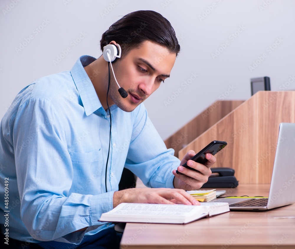 Call center operator working at his desk Call center operator working at his desk
