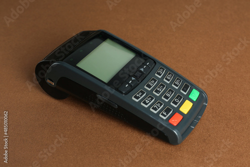 New modern payment terminal on brown background