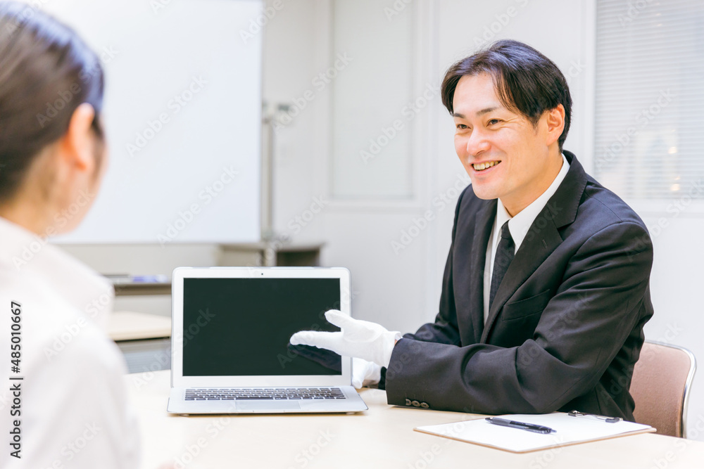 Obraz premium 打ち合わせをする白手袋をつけたビジネスマン（笑顔） 