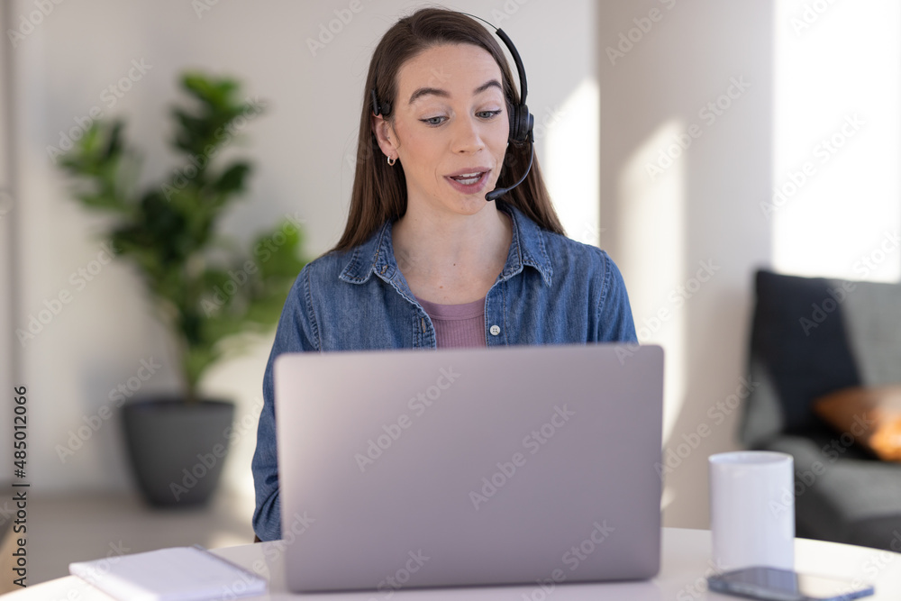 Caucasian woman at home remote working on laptop computer talking to her colleague Caucasian woman at home remote working on laptop computer talking to her colleague