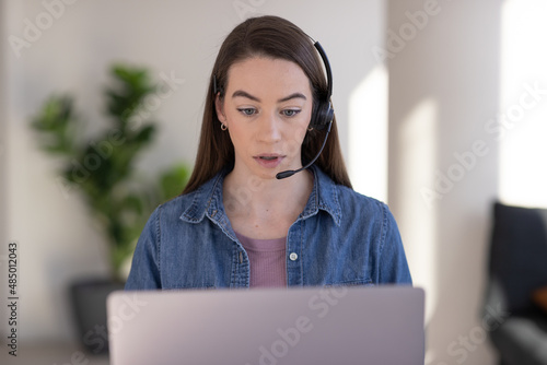 Caucasian woman at home remote working on laptop computer talking to her colleague