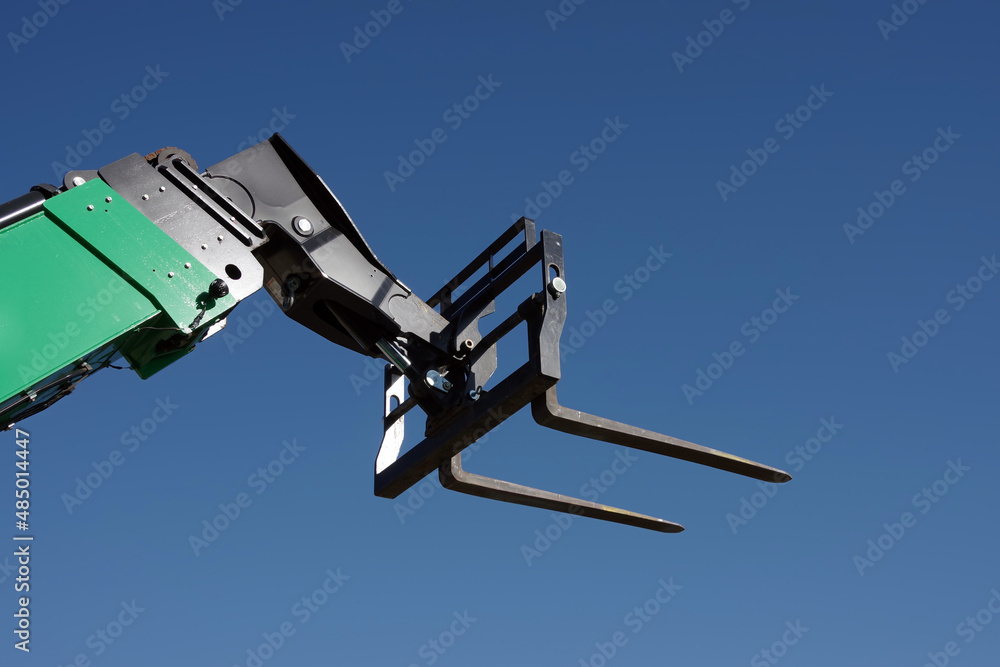 Close-up partial view of a heavy forklift under blue sky Close-up partial view of a heavy forklift under blue sky