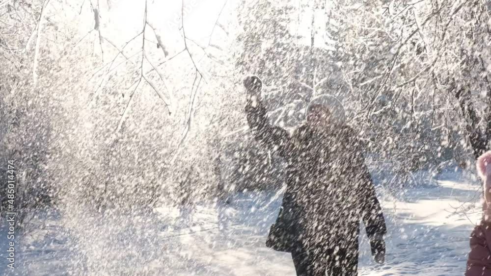Grandmother with granddaughter walking in snow on nice winter day.