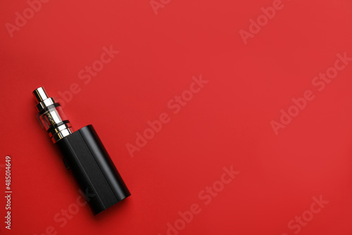 Electronic smoking device on red background, top view. Space for text