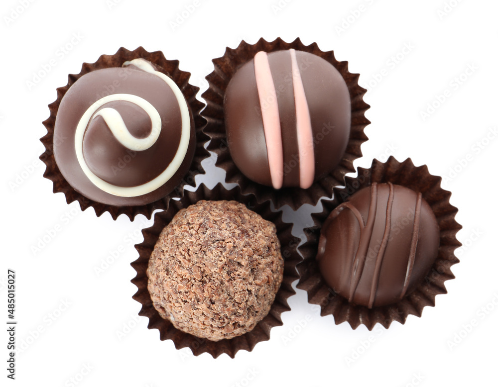 Many different delicious chocolate truffles on white background, top view Many different delicious chocolate truffles on white background, top view