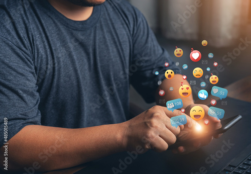 Fototapeta Naklejka Na Ścianę i Meble -  Hands holding and typing to communicate with others through emoji emotion. Online social communication,Social media,emotion, hearts. Chat Conversation on mobile. Man working using chatting application