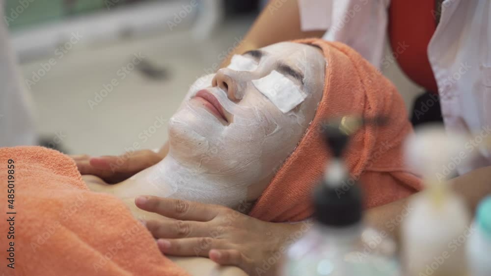 Close up Women with beautiful skin are being facial massaged by masseuses in a relaxed mood.Masseuses are applying facial masks all over the face for rejuvenation and facial treatments at spa shop. Close up Women with beautiful skin are being facial massaged by masseuses in a relaxed mood.Masseuses are applying facial masks all over the face for rejuvenation and facial treatments at spa shop.