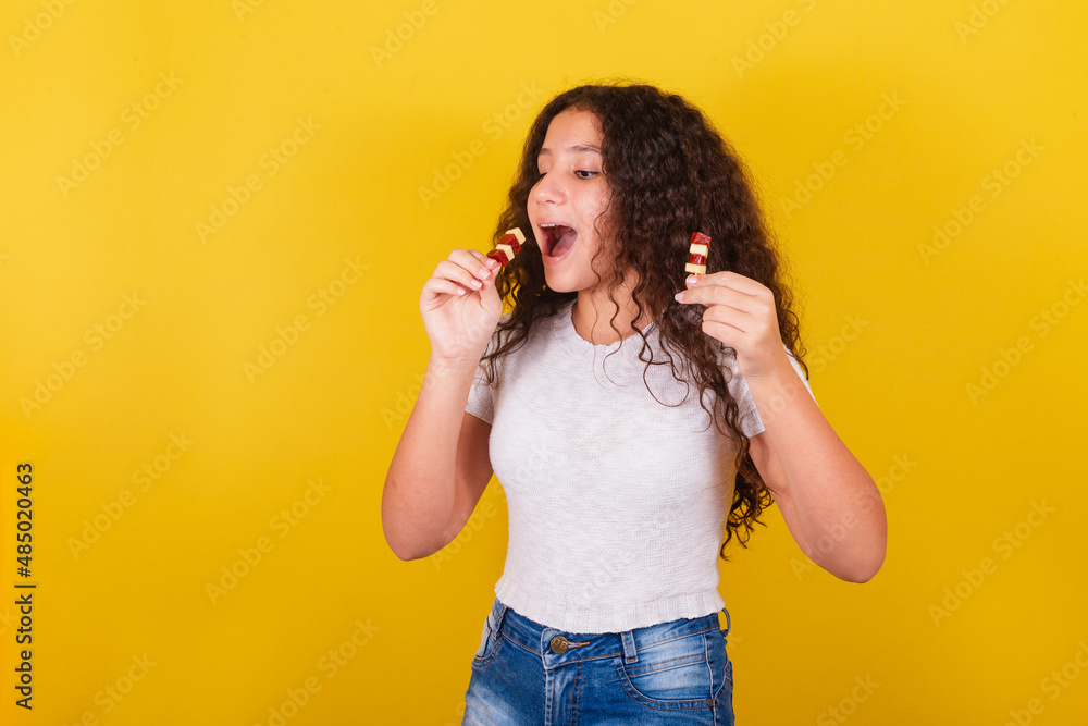 Φωτογραφία Afro brazilian, latin american girl with curly hair smiling, eating cheese and g