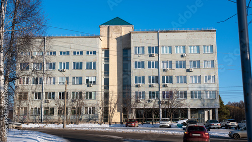 Road junction with moving cars against the backdrop of a tall building.