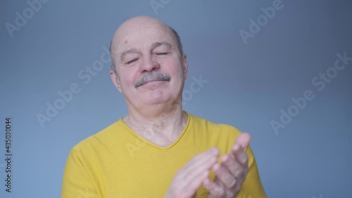 Senior man clapping and applauding happy and joyful, smiling proud