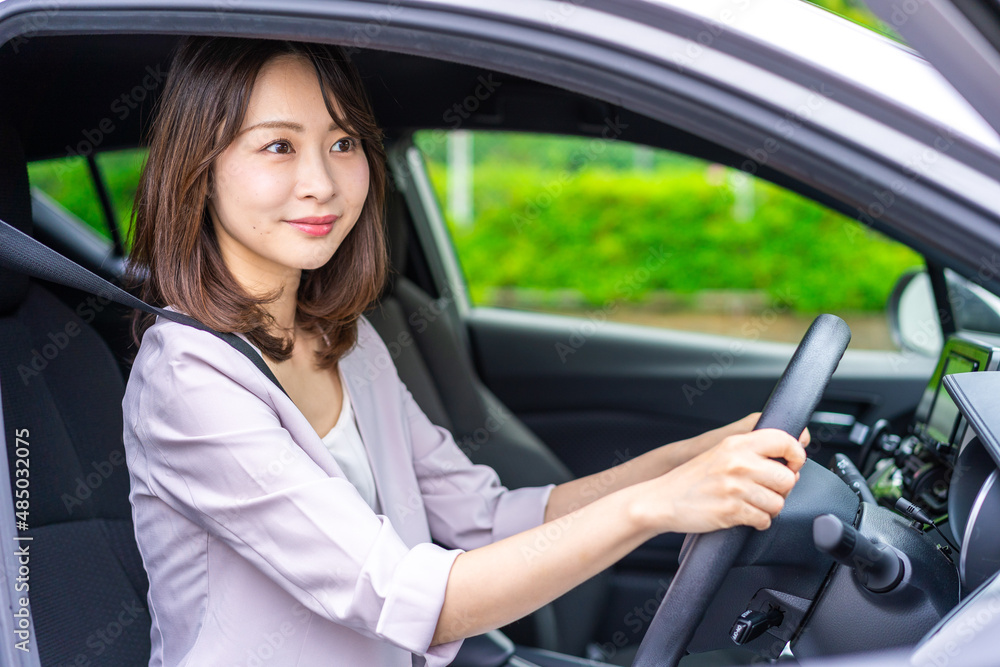 車を運転する若い女性