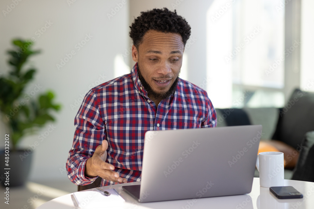 Black man at home remote working on laptop computer talking with colleague Black man at home remote working on laptop computer talking with colleague
