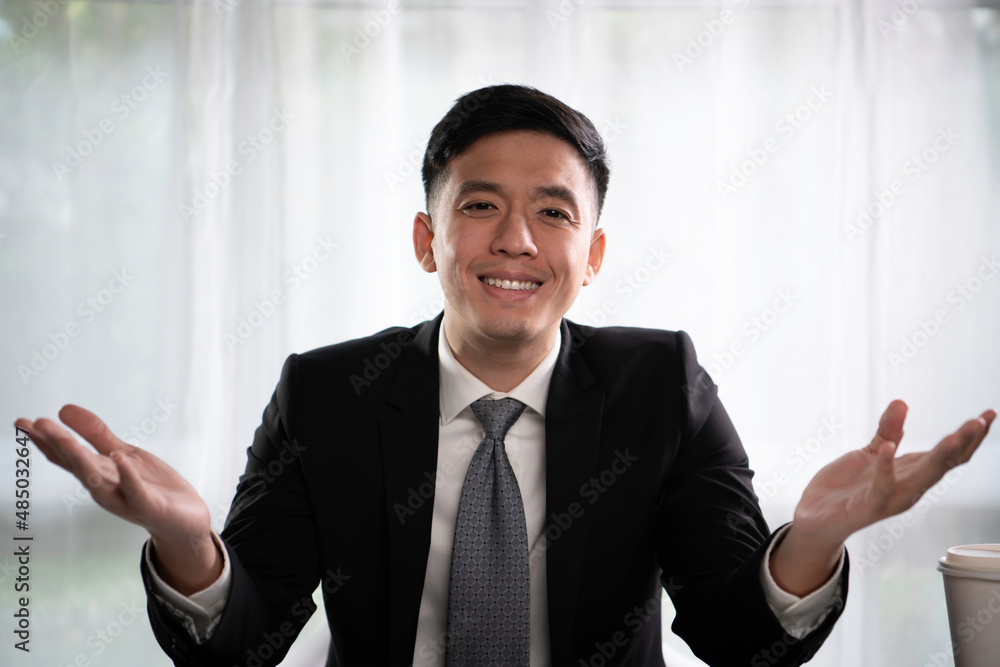 Handsome and successful Asian entrepreneur using hand gestures to present a project, talking to client and colleague, looking confident and assuring. 