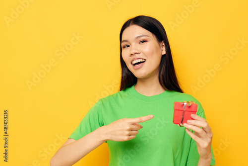Charming young Asian woman in green T-shirts with a small gift box Lifestyle unaltered