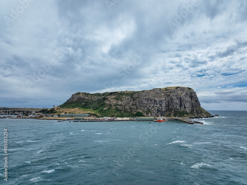 High angle aerial drone view of landmark the Nut, an extinct volcano table mountain, the harbour and the town of Stanley on the north-west coast of Tasmania, Australia on a stormy day with high waves. © Juergen Wallstabe