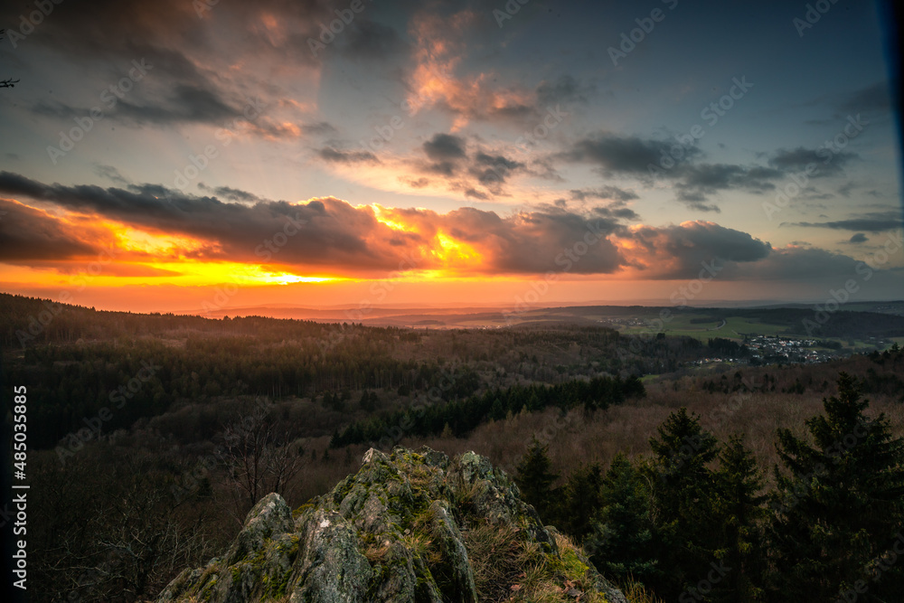 The peaks in the Taunus, near Frankfurt. Landscape photographed from a rock in a valley. Sunset with dramatic clouds in nature. View to the horizon in Germany