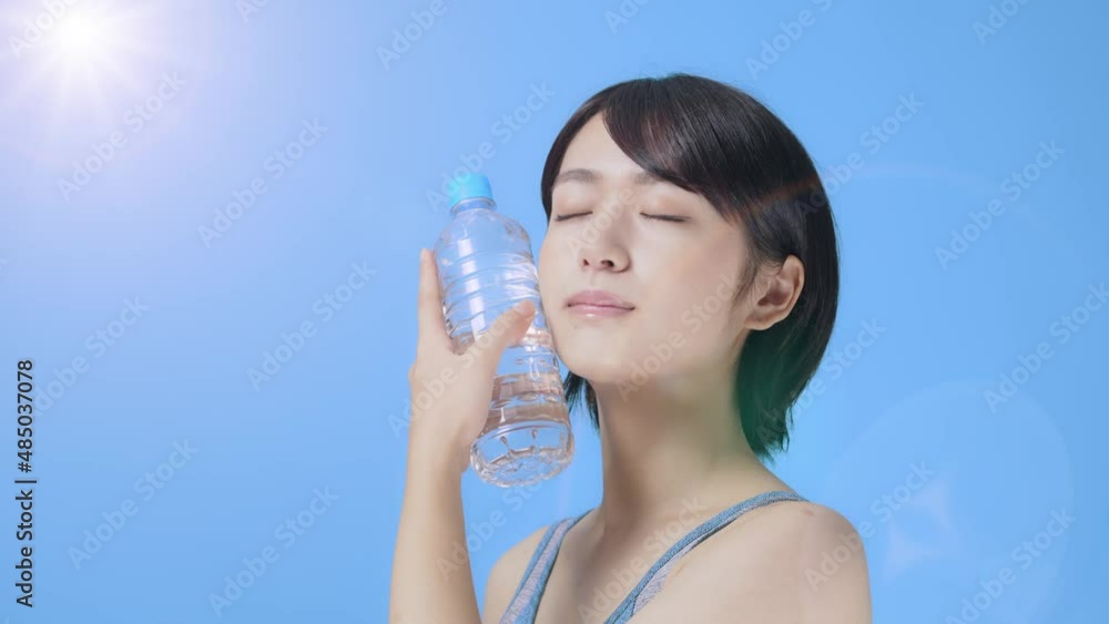 ペットボトルで顔を冷やす女性