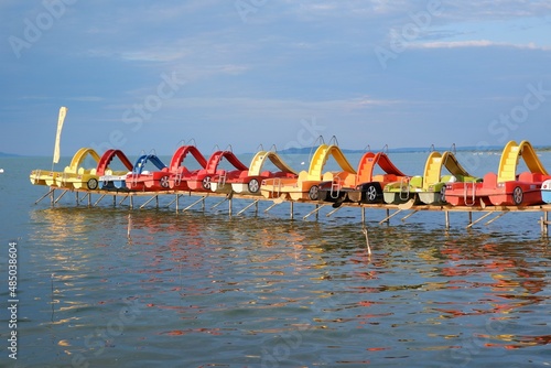 colorful pedal boats water bikes in row on the strand beach of the lake Balaton in Hungary in summer