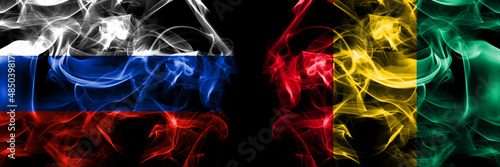 Russia, Russian vs Guinea flags. Smoke flag placed side by side isolated on black background