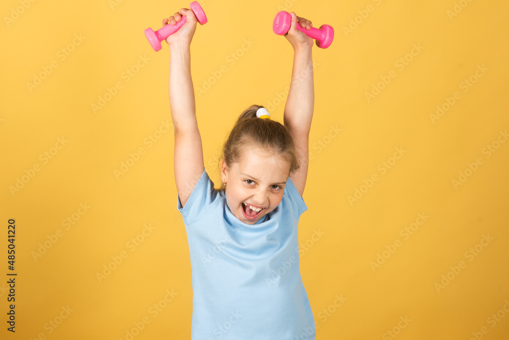 Excited sport and fitness girl, kids health and energy. Healthy children lifestyle. Cheerful boy do exercises with dumbbells. Girl exercising with dumbbells in studio, isolated. Sport portrait kids. Excited sport and fitness girl, kids health and energy. Healthy children lifestyle. Cheerful boy do exercises with dumbbells. Girl exercising with dumbbells in studio, isolated. Sport portrait kids.