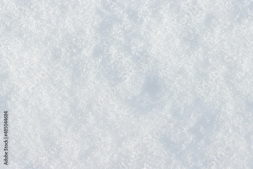 Natural snow texture. Smooth surface of clean fresh snow. Snowy ground. Winter background with snow patterns. Perfect for Christmas and New Year design. Closeup top view.