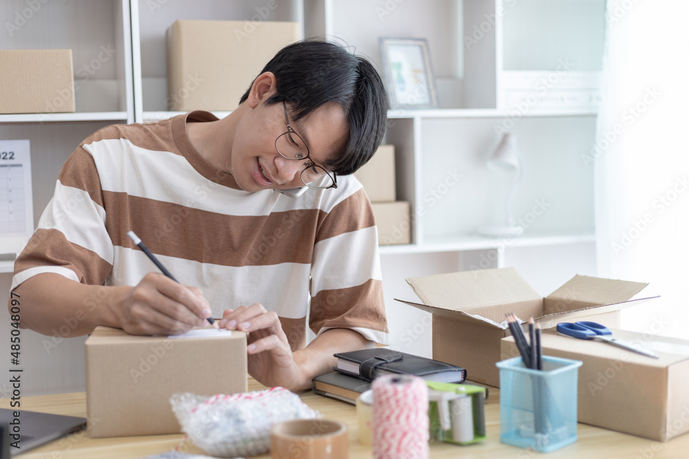 Asian man is taking online orders from a phone and chatting with customers to confirm their order, Selling products online or doing freelance work at home, Working at home and owning businesses. Asian man is taking online orders from a phone and chatting with customers to confirm their order, Selling products online or doing freelance work at home, Working at home and owning businesses.