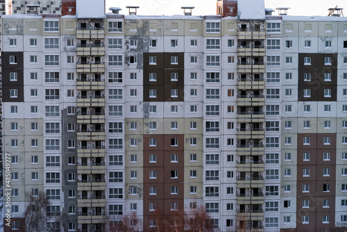 Windows and balconies of the residential building. Old urban obsolete facade of panel house. The windows of an ordinary soviet building.