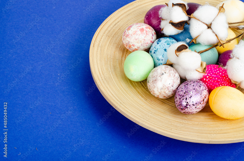 Obraz premium Decorated handmade Easter eggs for the holiday season on blue background. Creative minimal abstract concept. Studio Photo