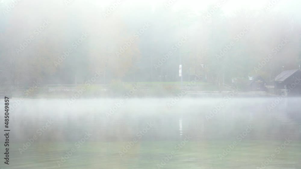 Fog moving on the surface of Bohinj Lake, Slovenia. View of pond shore. Calm water on misty morning. Autumn or fall season. Static shot, real time Fog moving on the surface of Bohinj Lake, Slovenia. View of pond shore. Calm water on misty morning. Autumn or fall season. Static shot, real time