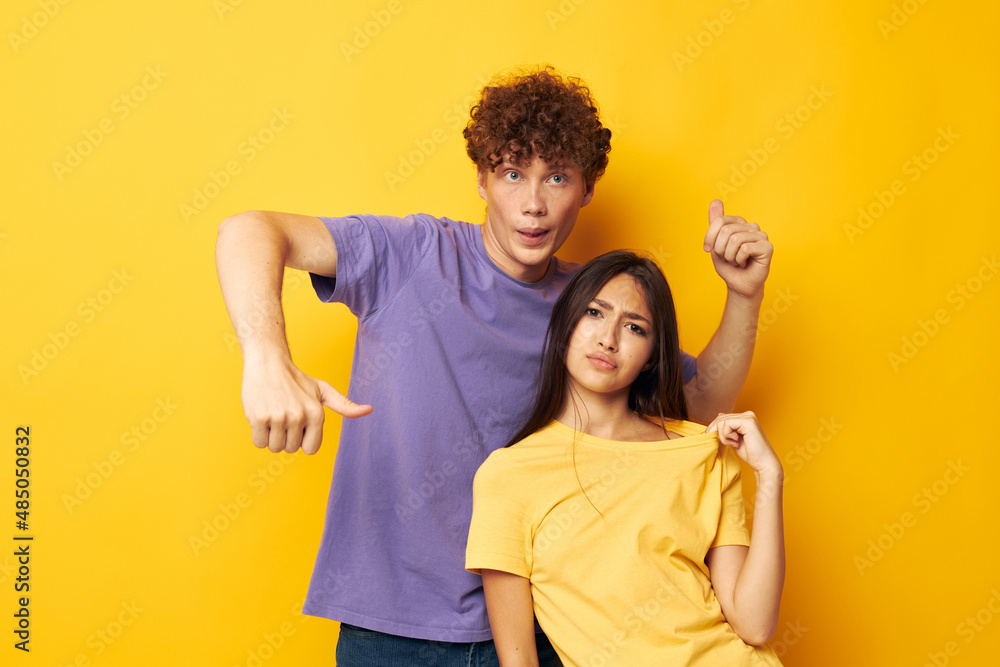 Obraz premium portrait of a man and a woman casual clothes posing emotions antics yellow background unaltered