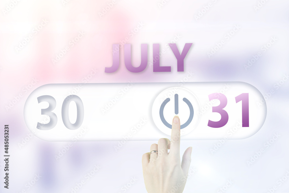 Fototapeta premium July 31st . Day 31 of month, Calendar date.Hand finger switches pointing calendar date on sunlight office background. Summer month, day of the year concept.