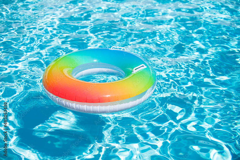 Inflatable ring in blue swimming pool. Summer pool water perfect background.